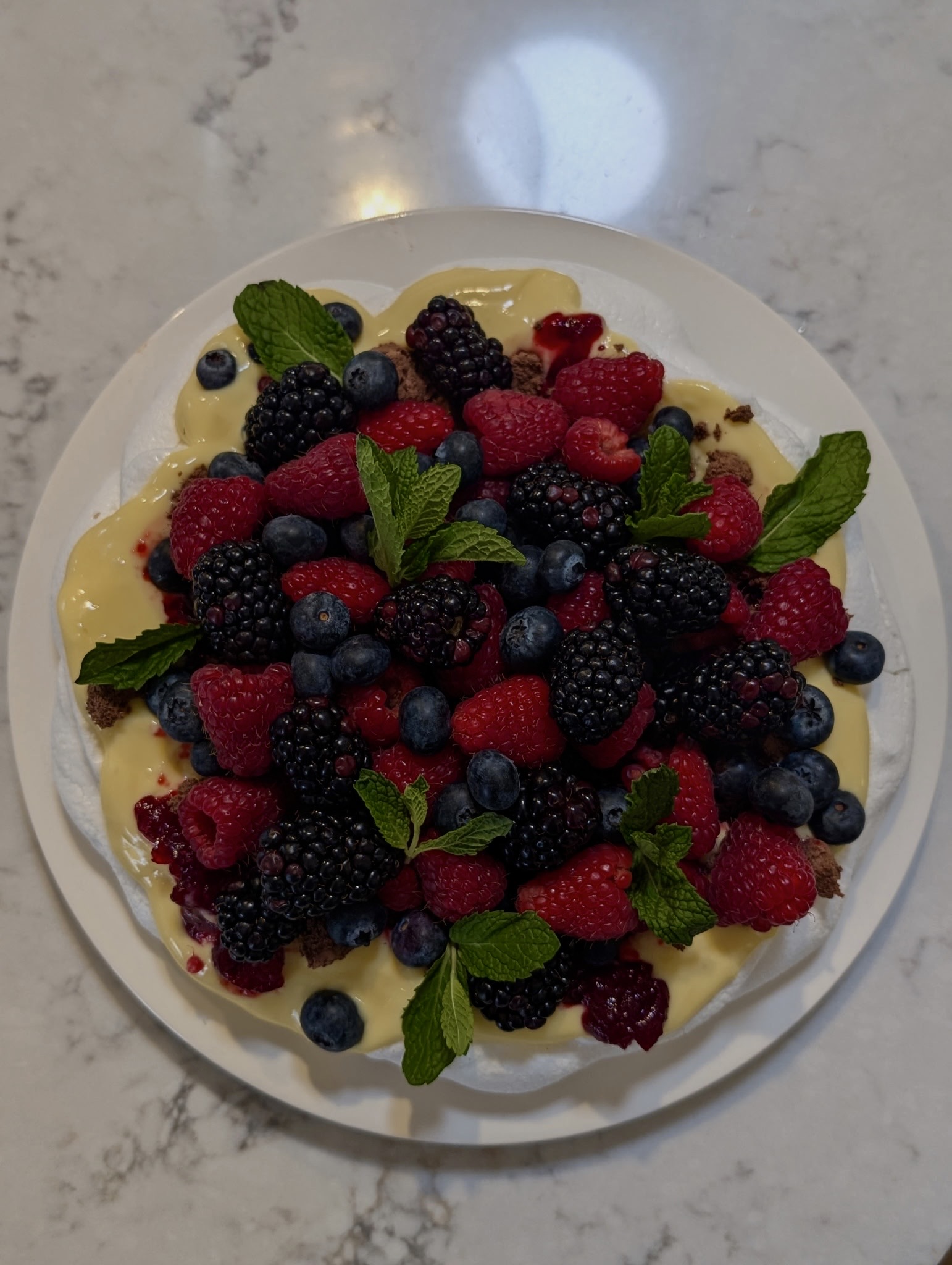 Berry dessert with custard and fresh mint